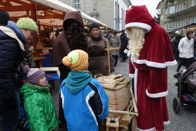 Samichlaus und Schmutzli mit Leiterwagen und Gabensack am Weihnachtsmarkt